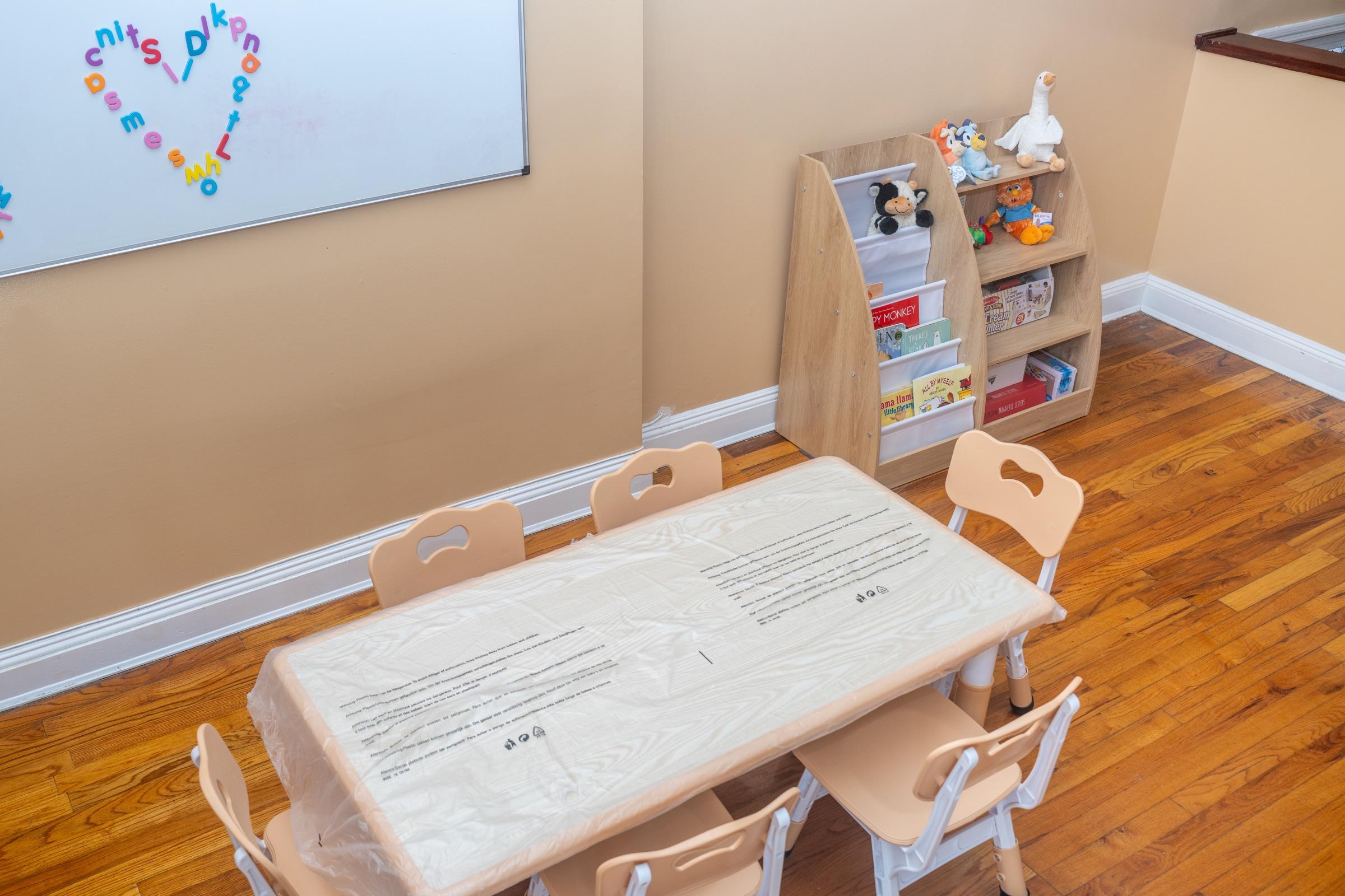 Learning table with child-sized chairs and books nearby.