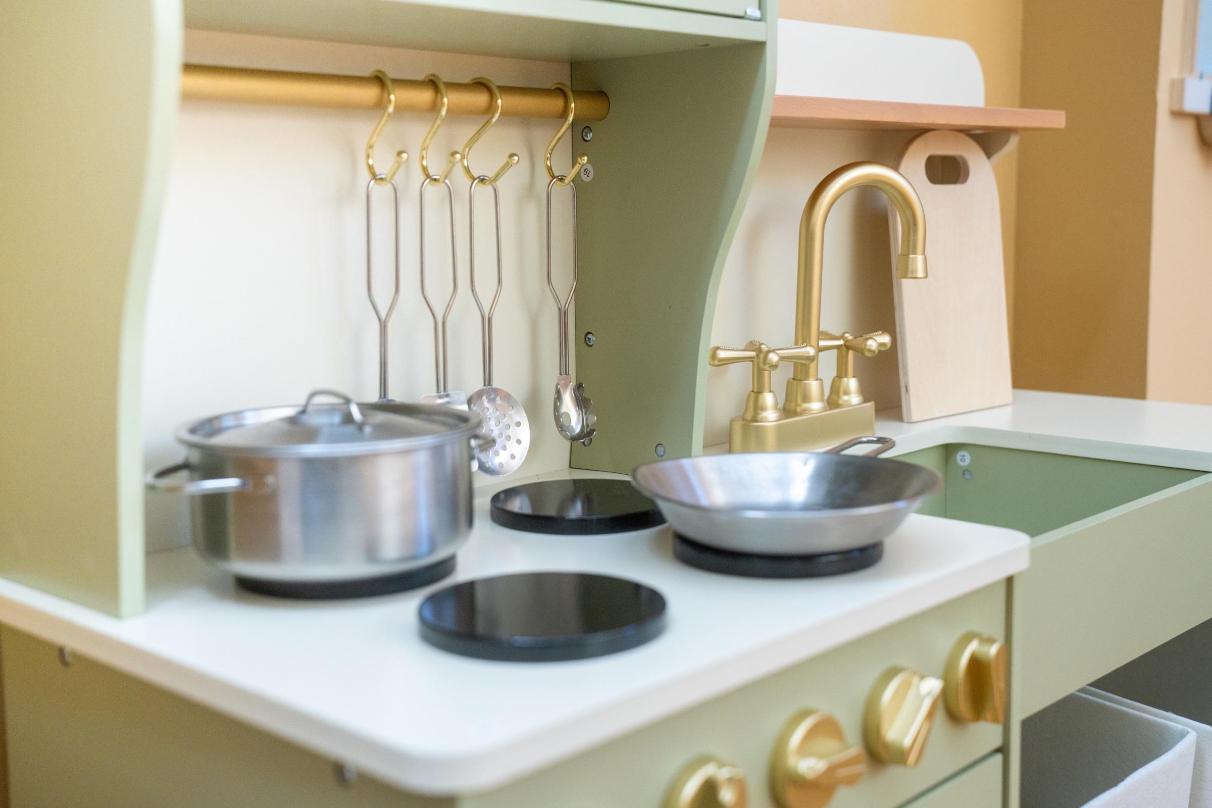 Pretend kitchen with pots, pans, and play sink.